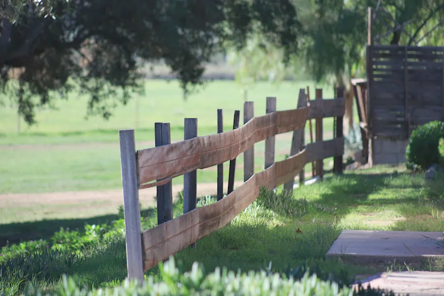 Old two-rail wooden fence sagging between posts